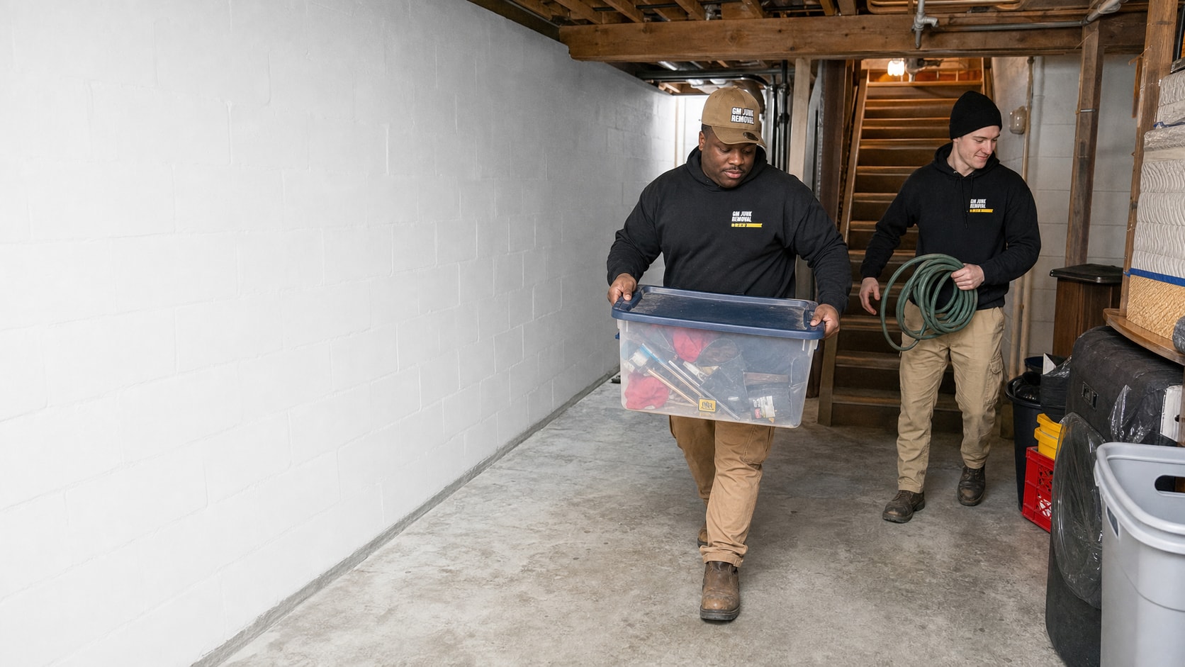 Crew carrying boxes out of a basement